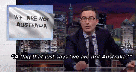 A Man Sitting At A Desk With A Flag That Says We Are Not Australia On It GIF