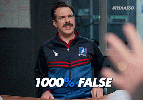 A Man Sitting At A Desk With A Jacket That Says 1000 % False GIF