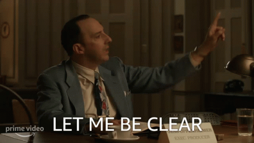 A Man Sitting At A Desk With A Sign That Says Exec Producer On It GIF