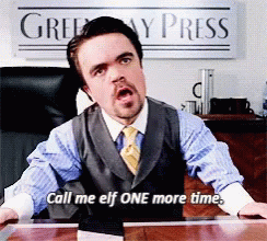 A Man Sitting At A Desk With A Sign That Says Greenway Press GIF