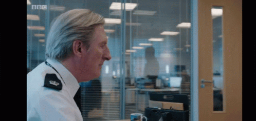 A Man Sitting At A Desk With Bbc Written On The Bottom Right GIF