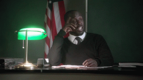 A Man Sitting At A Desk With The Words " Can I Object " Behind Him GIF