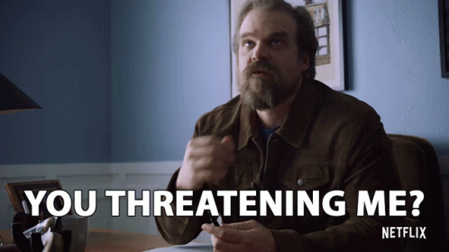 A Man Sitting At A Desk With The Words You Threatening Me GIF