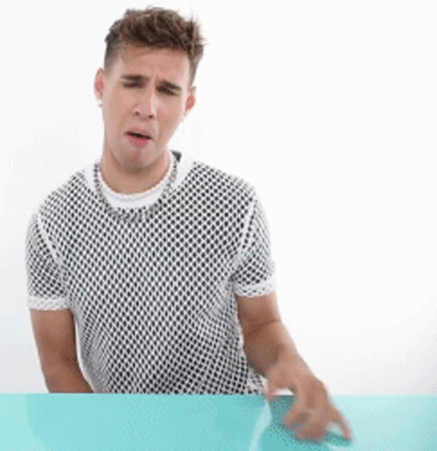 A Man Sitting At A Table Wearing A Mesh Shirt GIF