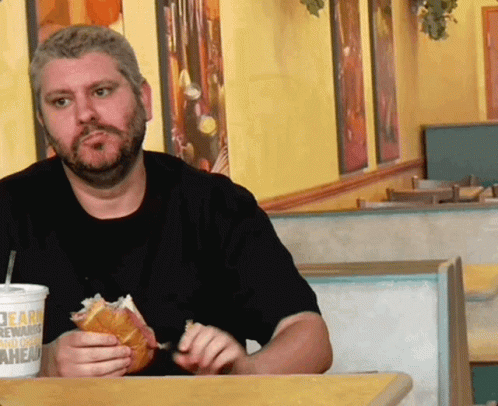 A Man Sitting At A Table With A Burger King Drink GIF