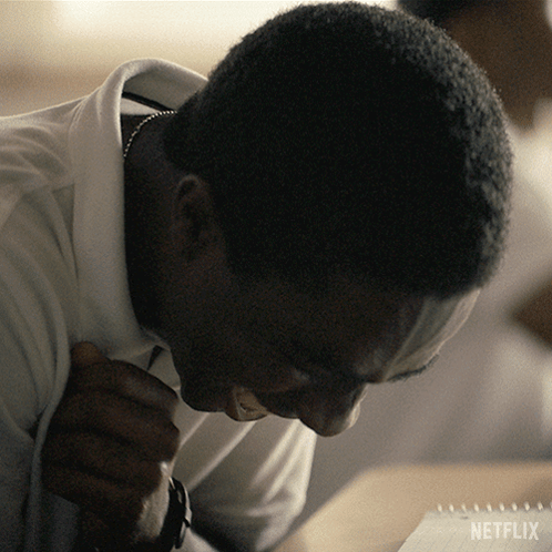 A Man Sitting At A Table With A Netflix Logo On The Bottom Right GIF