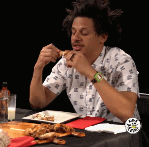 A Man Sitting At A Table With A Plate Of Food And A First We Feast Logo GIF