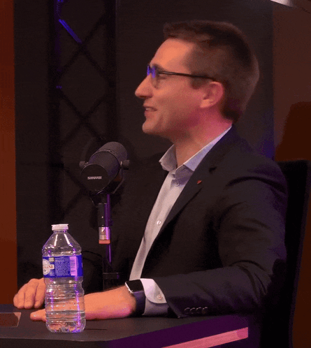 a man sitting at a table with a shure microphone