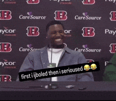 a man sitting at a table with a sign that says " first i boiled then i serious "