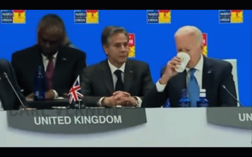Man Sitting At Table With United Kingdom Sign GIF