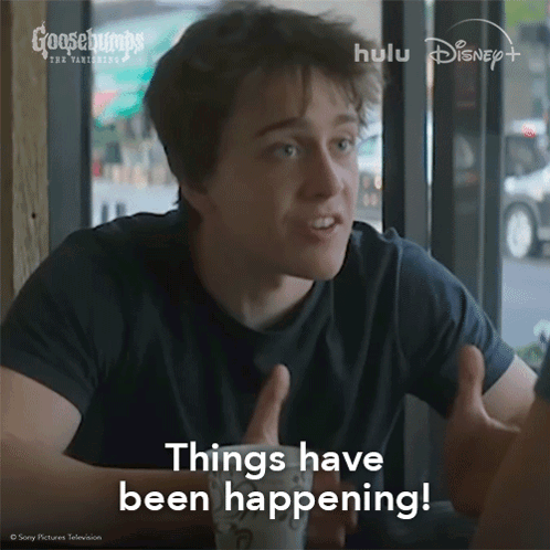 A Man Sitting At A Table With His Hands Out And The Words Things Have Been Happening Above Him GIF