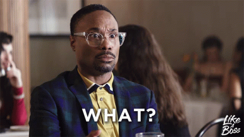 A Man Sitting At A Table With The Word What Written On His Face GIF