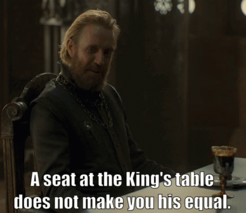 A Man Sitting At A Table With The Words A Seat At The King 'S Table Does Not Make You GIF