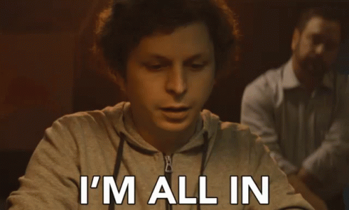 A Man Sitting At A Table With The Words I 'M All In Written On His Face GIF