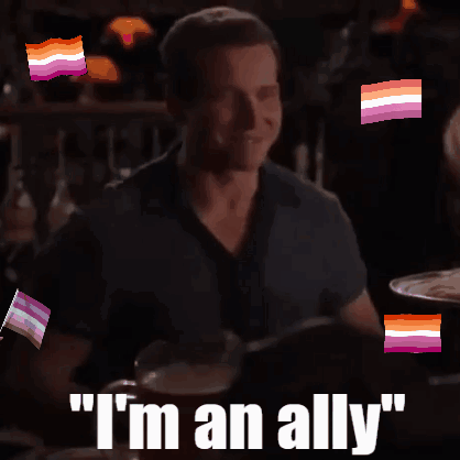 A Man Sitting At A Table With The Words " I 'M An Ally " On The Bottom GIF