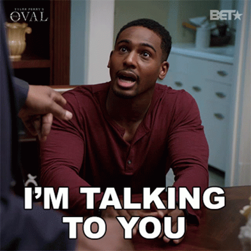 A Man Sitting At A Table With The Words I 'M Talking To You GIF