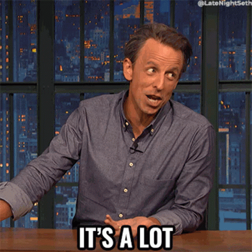A Man Sitting At A Table With The Words It 'S A Lot On His Face GIF