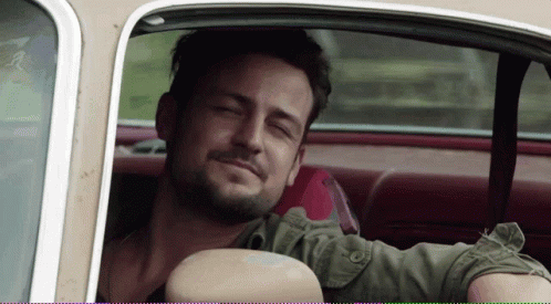 A Man Sitting In A Car With His Eyes Closed Smiling GIF
