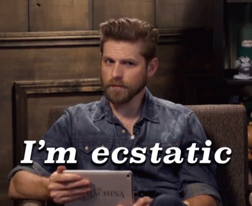 A Man Sitting In A Chair Holding A Tablet With The Words I 'M Ecstatic Written On It GIF