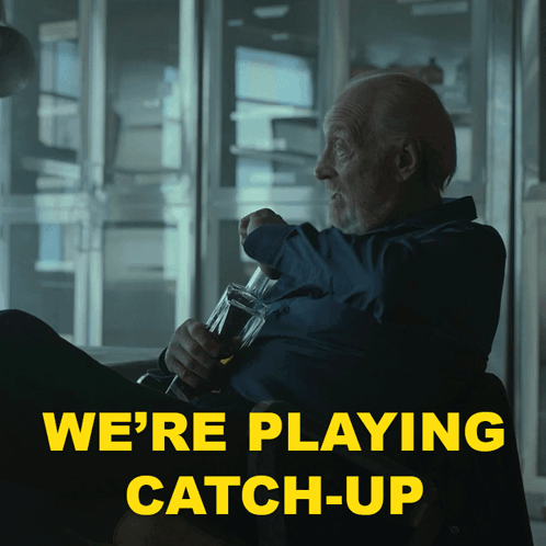 a man sitting in a chair with a bottle of beer and the words we 're playing catch-up above him