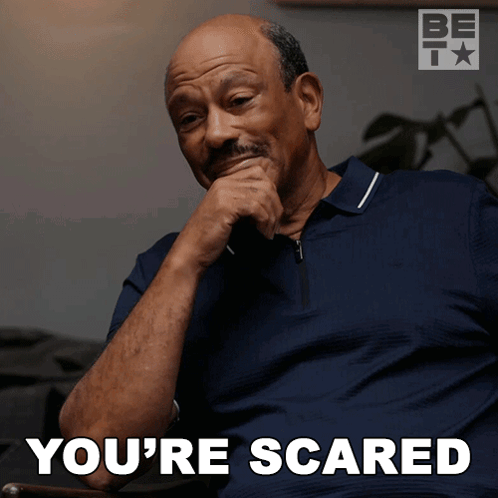 A Man Sitting In A Chair With His Hand On His Chin And The Words You 'Re Scared Below Him GIF