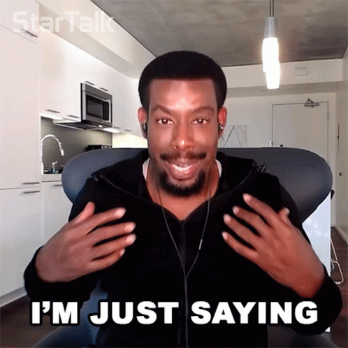 A Man Sitting In A Chair With The Words " I 'M Just Saying " On The Bottom GIF