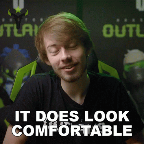 a man sitting in a chair with the words it does look comfortable behind him
