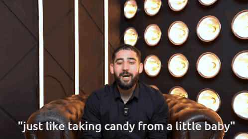 A Man Sitting In A Chair With The Words " Just Like Taking Candy From A Little Baby " On The Bottom GIF