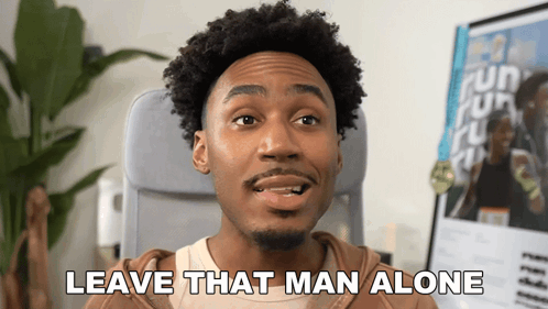 A Man Sitting In A Chair With The Words Leave That Man Alone Above Him GIF