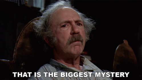 A Man Sitting In A Chair With The Words That Is The Biggest Mystery Above Him GIF