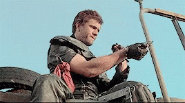 A Man Sitting In A Vehicle With A Gun In His Hand GIF
