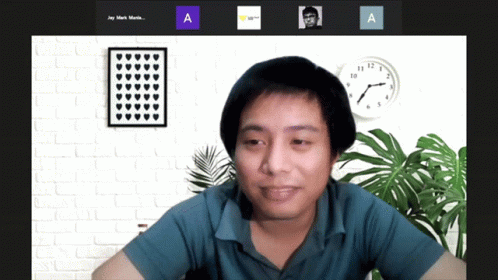 A Man Sitting In Front Of A Clock With The Letters A And A Next To Him GIF