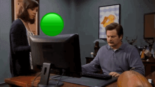 A Man Sitting In Front Of A Computer With A Green Screen GIF