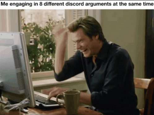 A Man Sitting In Front Of A Computer With A Mug In Front Of Him GIF