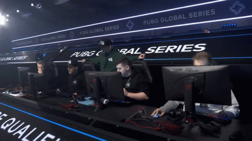 A Man Sitting In Front Of A Computer With A Sign That Says Pubg Global Series GIF