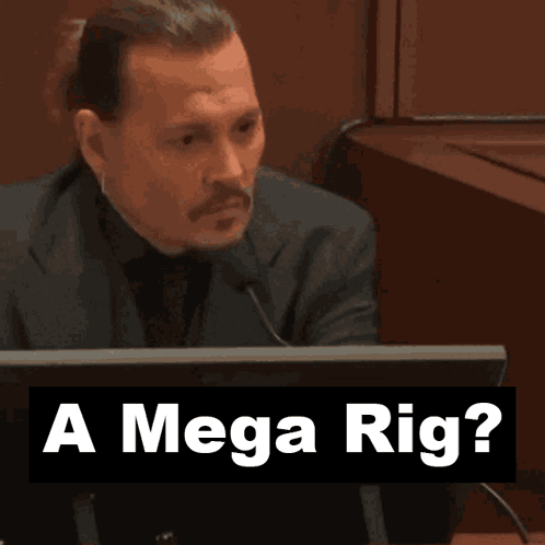 A Man Sitting In Front Of A Computer With The Words " A Mega Rig " Behind Him GIF