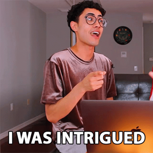 A Man Sitting In Front Of A Laptop With The Words I Was Intrigued On The Screen GIF