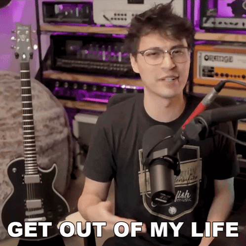Man Sitting In Front Of Microphone Saying Get Out Of My Life GIF