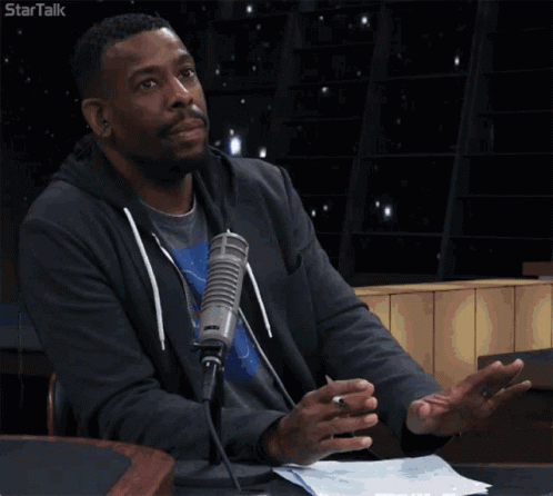A Man Sitting In Front Of A Microphone With The Words I 'M Just Saying GIF