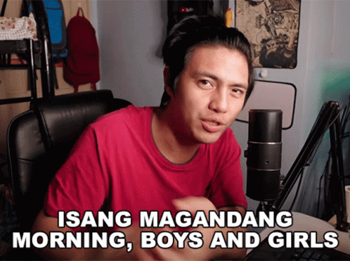 A Man Sitting In Front Of A Microphone With The Words Isang Magandang Morning Boys And Girls Above Him GIF