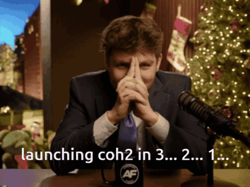 A Man Sitting In Front Of A Microphone With The Words Launching Coh2 In 3 In The Corner GIF
