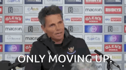 A Man Sitting In Front Of A Microphone With The Words `` Only Moving Up '' Written Below Him . GIF
