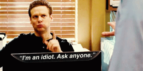 A Man Sitting In Front Of A Monitor That Says I 'M An Idiot Ask Anyone GIF