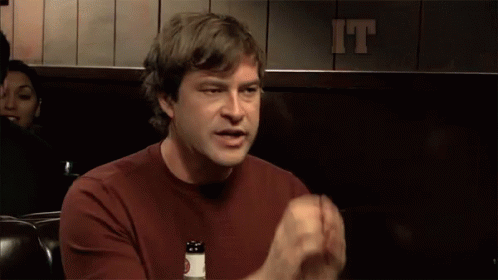A Man Sitting In Front Of A Sign That Says It Is Decided On It GIF