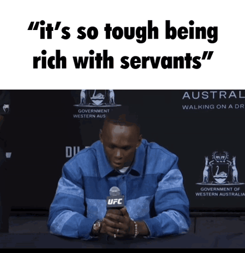 A Man Sitting In Front Of A Sign That Says ' It 'S So Tough Being Rich With Servants " GIF