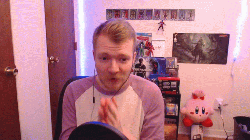 A Man Sitting In Front Of A Sign That Says ' Spiderman 2 ' On It GIF