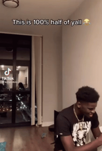 A Man Sitting In Front Of A Window With The Caption " This Is 100 % Half Of Y'all " GIF