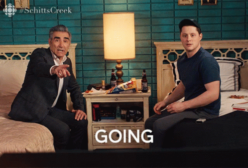A Man Sitting On A Bed Next To Another Man Who Is Sitting On A Bed With The Word Going In Front Of Them GIF
