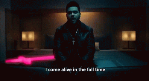 A Man Sitting On A Bed With The Words " I Come Alive In The Fall Time " Written Below Him GIF