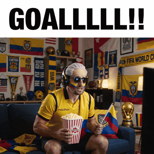 a man sitting on a couch eating popcorn and wearing a marathon jersey